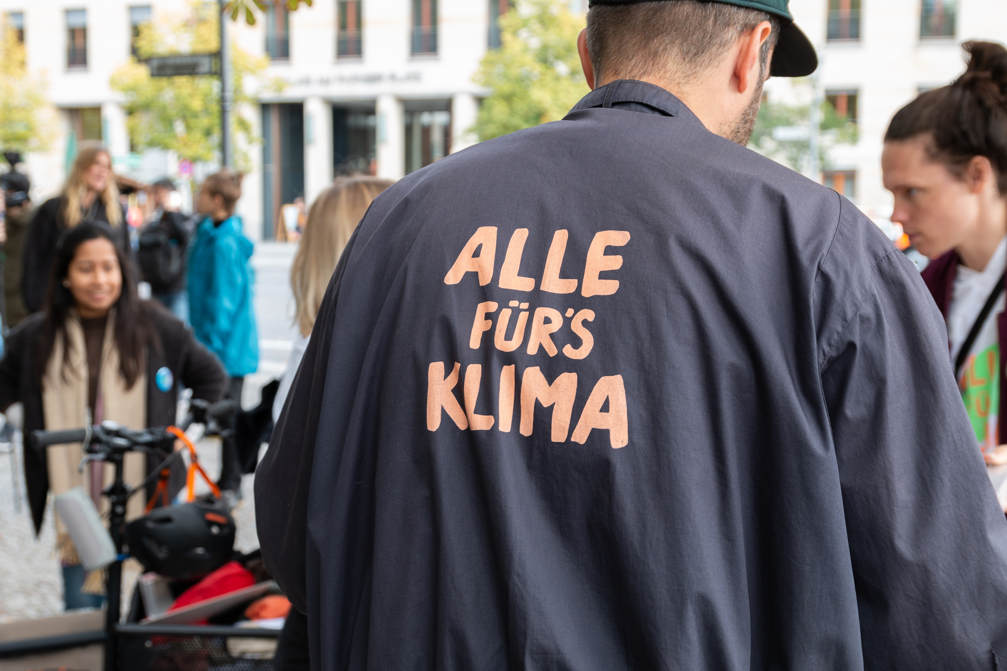 Mann mit Pullover mit Aufschrift ALLE FÜR'S KLIMA